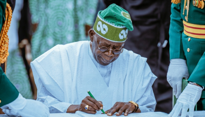 President Bola Tinubu with cryptocurrency symbols, the Nigerian flag, and regulatory documents, representing the signing of an executive order to coordinate crypto regulation.