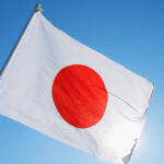Japan's flag alongside cryptocurrency symbols, financial market charts, blockchain technology graphics, and government regulatory documents representing crypto tax reform